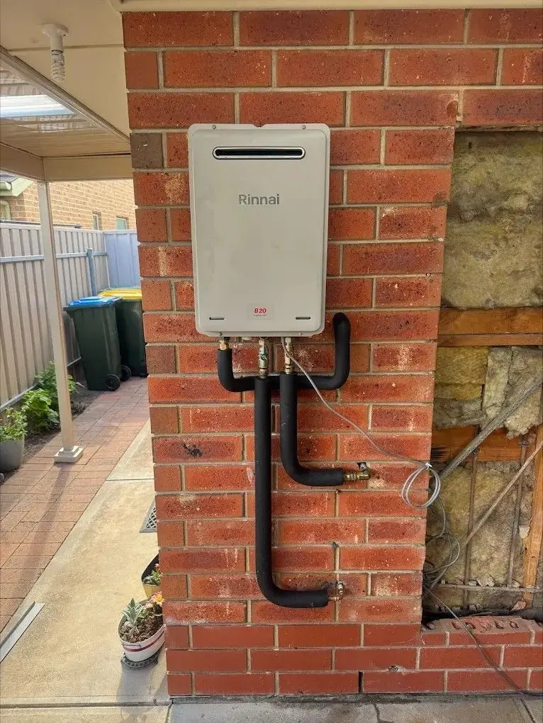 Gas continuous flow hot water unit mounted on an external brick wall