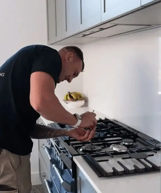 Steven Seery testing gas burners on a newly connected cooktop